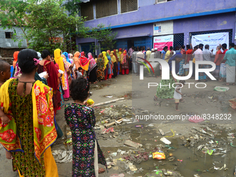 Slum dwellers wait to receive a Booster Dose of COVID-19 vaccine at a makeshift vaccination center during a national campaign at Karail Slum...