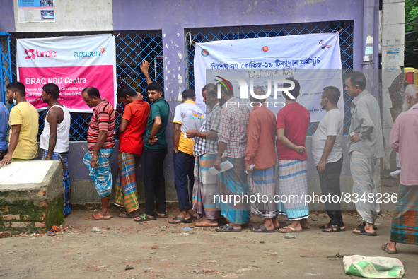 Slum dwellers wait to receive a Booster Dose of COVID-19 vaccine at a makeshift vaccination center during a national campaign at Karail Slum...