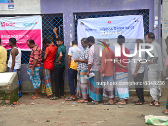 Slum dwellers wait to receive a Booster Dose of COVID-19 vaccine at a makeshift vaccination center during a national campaign at Karail Slum...