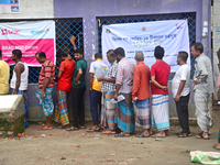 Slum dwellers wait to receive a Booster Dose of COVID-19 vaccine at a makeshift vaccination center during a national campaign at Karail Slum...