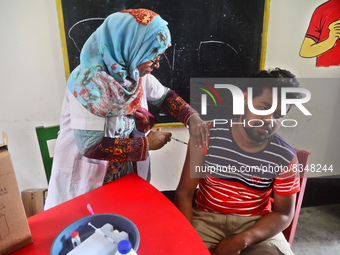 Slum dweller receives a Booster Dose of COVID-19 vaccine at a makeshift vaccination center during a national campaign at Karail Slum in Dhak...