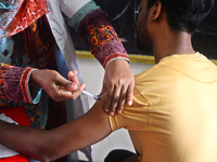 Slum dweller receives a Booster Dose of COVID-19 vaccine at a makeshift vaccination center during a national campaign at Karail Slum in Dhak...