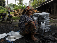 Female worker is packing the charcoal. Kampung Keluat, Kelantan / Malaysia. *360 hours of waiting. 50 Cent's happy. Charcoal needs 360 hours...