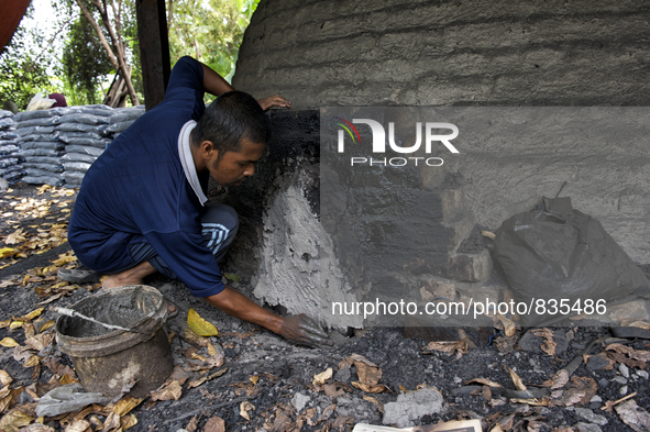 Male worker is blocked a hole on the dome / Kampung Keluat, Kelantan / Malaysia. *360 hours of waiting. 50 Cent's happy. Charcoal needs 360...