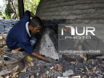 Male worker is blocked a hole on the dome / Kampung Keluat, Kelantan / Malaysia. *360 hours of waiting. 50 Cent's happy. Charcoal needs 360...