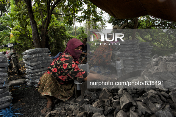 Female worker is using a sickle for sorting the charcoals / Kampung Keluat, Kelantan / Malaysia. *360 hours of waiting. 50 Cent's happy. Cha...