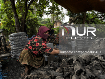 Female worker is using a sickle for sorting the charcoals / Kampung Keluat, Kelantan / Malaysia. *360 hours of waiting. 50 Cent's happy. Cha...