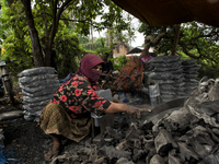 Female worker is using a sickle for sorting the charcoals / Kampung Keluat, Kelantan / Malaysia. *360 hours of waiting. 50 Cent's happy. Cha...