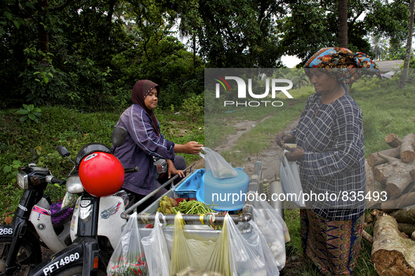 Female worker is buying some food from a small mobile shop. There is no market near to their village / Kampung Keluat, Kelantan / Malaysia....