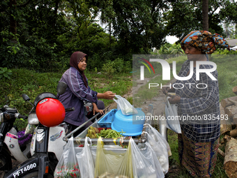 Female worker is buying some food from a small mobile shop. There is no market near to their village / Kampung Keluat, Kelantan / Malaysia....