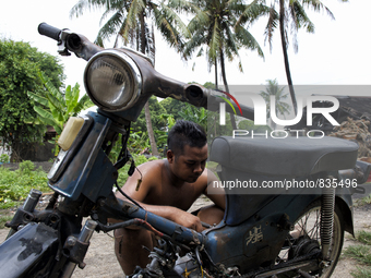 Male worker is repairing his a motorbike / Kampung Keluat, Kelantan / © Chris Jung
 (