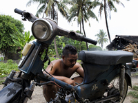 Male worker is repairing his a motorbike / Kampung Keluat, Kelantan / © Chris Jung
 (