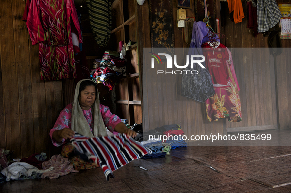 Female worker is fold up the laundries / Kampung Keluat, Kelantan / © Chris Jung
 