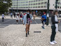 A group of people is seen walking along a nearby avenue that crosses the vicinity of Eduardo VII Gardens. Lisbon, June 03, 2022. According t...