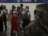 A group of people watch José Miguel Moctezuma, characterised as Don Ferro Ferrocarrilero, during a performance as a living statue inside the...