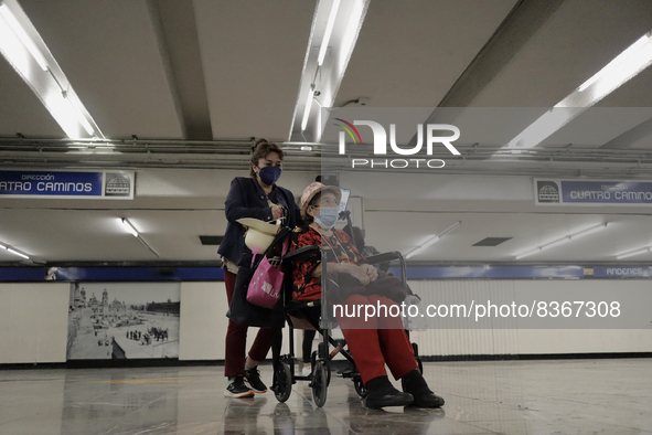 A group of people watch José Miguel Moctezuma, characterised as Don Ferro Ferrocarrilero, during a performance as a living statue inside the...