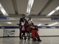 A group of people watch José Miguel Moctezuma, characterised as Don Ferro Ferrocarrilero, during a performance as a living statue inside the...