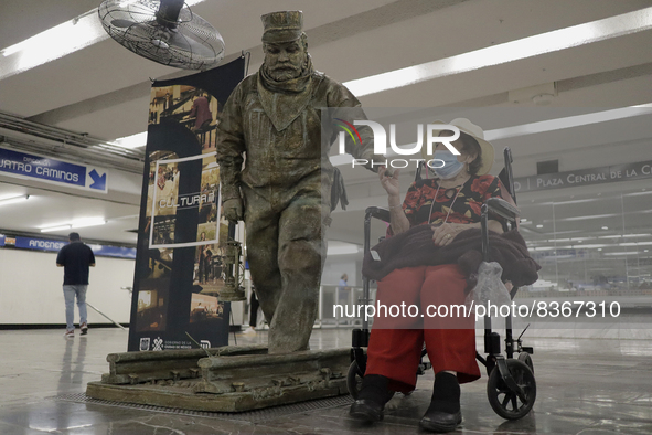 José Miguel Moctezuma, characterised as Don Ferro Ferrocarrilero, lives with an elderly woman during a performance as a living statue inside...