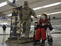 José Miguel Moctezuma, characterised as Don Ferro Ferrocarrilero, lives with an elderly woman during a performance as a living statue inside...