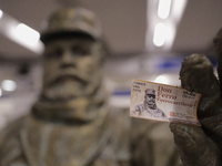 José Miguel Moctezuma, characterised as Don Ferro Ferrocarrilero, holds a ticket with his image during a performance as a living statue insi...