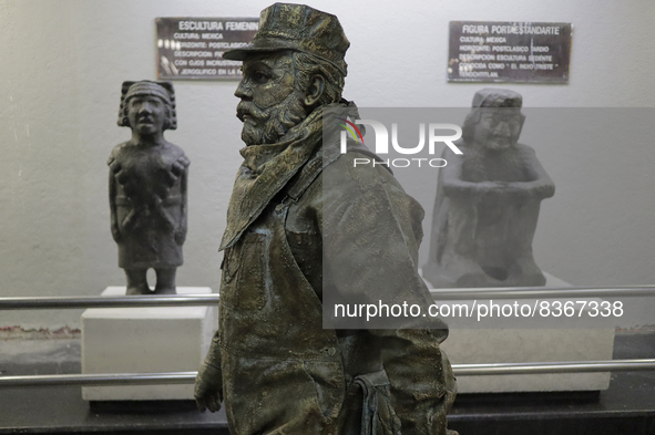 José Miguel Moctezuma, characterised as Don Ferro Ferrocarrilero, between two replicas of pre-Hispanic pieces during a performance as a livi...