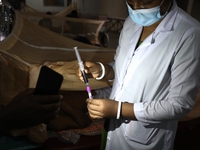 A medical worker collects sample blood of a dengue patient in a special ward of Mugda general hospital in Dhaka, Bangladesh on June 11, 2022...