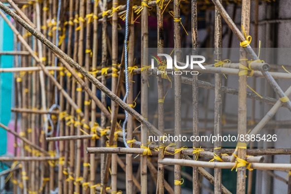 Hong Kong, China, 11 Jun 2022, Bamboo scaffoldings are held together with yellow plastic binders. 