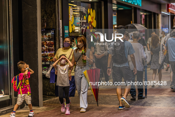 Hong Kong, China, 11 Jun 2022, A family wearing face masks walks on Sai Yeung Choi South Street in Mongkok. 