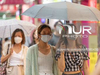 Hong Kong, China, 11 Jun 2022, Two young ladies walk under an umbrella in Sai Yeung Choi South Street in Mongkok. (