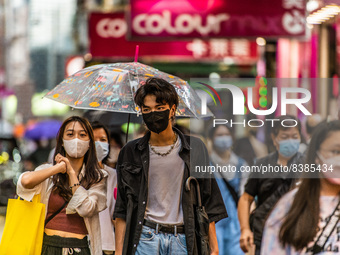 Hong Kong, China, 11 Jun 2022, Masked young people walk on Sai Yeung Choi South Street in Mongkok. (