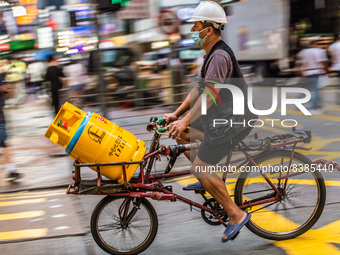 Hong Kong, China, 11 Jun 2022, A delivery man carries bottles of LPG gas on his bicycle in Mongkok. (