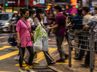 Hong Kong, China, 11 Jun 2022, People cross a street in Mongkok in this panned shot. (