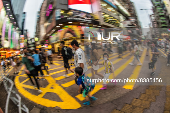 Hong Kong, China, 11 Jun 2022, A masked family crosses a street in Mongkok on a rainy day. 