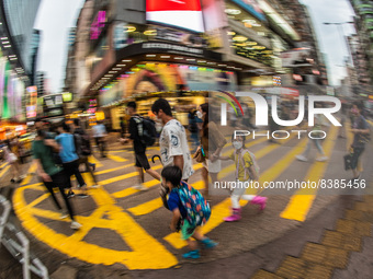 Hong Kong, China, 11 Jun 2022, A masked family crosses a street in Mongkok on a rainy day. (