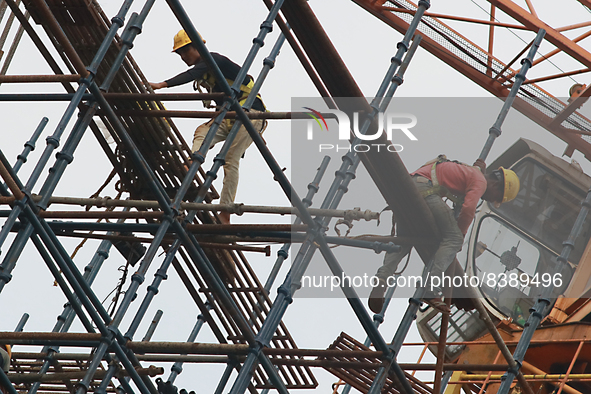  Labourers work at a construction site of a metro rail station in Kolkata, India, June 12,2022. 