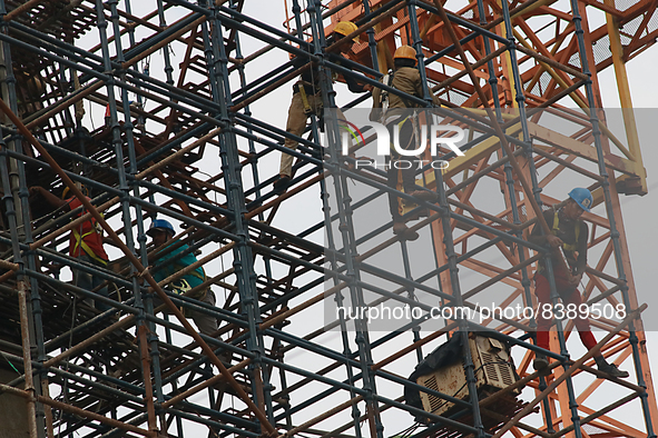  Labourers work at a construction site of a metro rail station in Kolkata, India, June 12,2022. 