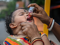 A child receives polio drops during a pulse polio immunisation programme in Kolkata on June 19 2022. The immunisation programme started in a...