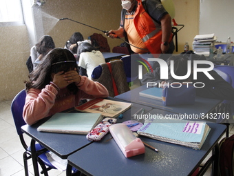 Civil Protection workers spread disinfectant inside class rooms of a primary school  to avoid new Covid-19 infections after an increase of C...