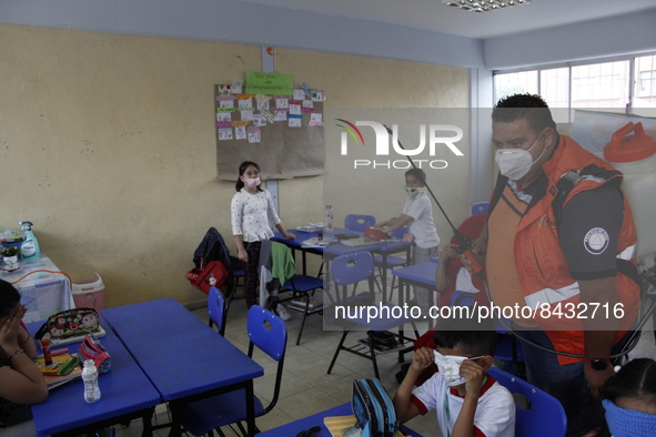 Civil Protection workers spread disinfectant inside class rooms of a primary school  to avoid new Covid-19 infections after an increase of C...