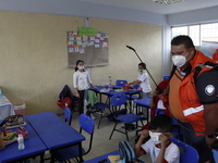 Civil Protection workers spread disinfectant inside class rooms of a primary school  to avoid new Covid-19 infections after an increase of C...