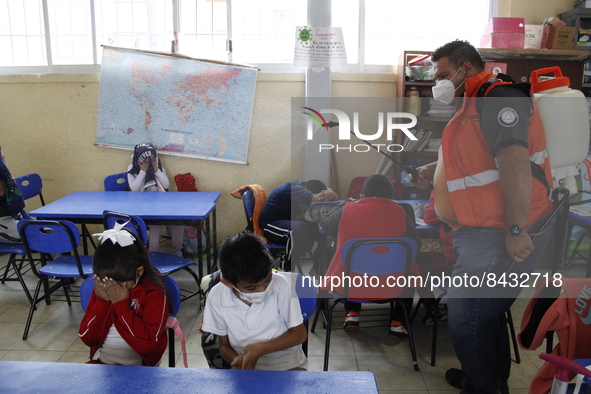 Civil Protection workers spread disinfectant inside class rooms of a primary school  to avoid new Covid-19 infections after an increase of C...