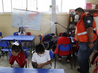 Civil Protection workers spread disinfectant inside class rooms of a primary school  to avoid new Covid-19 infections after an increase of C...