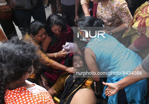 A Member of the Samagi Vanitha Balawegaya faints, during a protest near Sri Lanka's Prime Minister Ranil Wickremesinghe's private residence,...