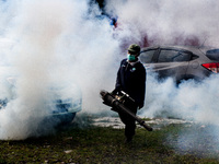 A health worker fumigates to kill mosquito larvae to fight against the spread of dengue fever in Bogor, West Java, Indonesia on June 26, 202...