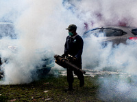 A health worker fumigates to kill mosquito larvae to fight against the spread of dengue fever in Bogor, West Java, Indonesia on June 26, 202...