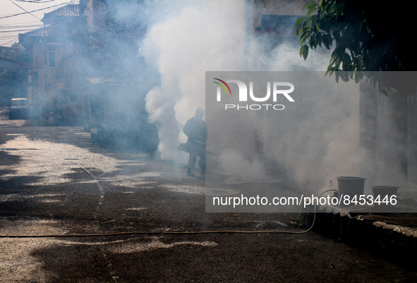 A health worker fumigates to kill mosquito larvae to fight against the spread of dengue fever in Bogor, West Java, Indonesia on June 26, 202...