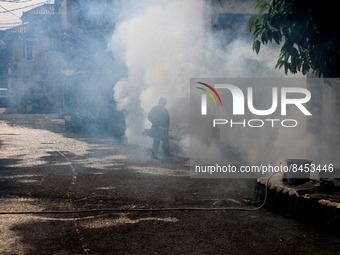 A health worker fumigates to kill mosquito larvae to fight against the spread of dengue fever in Bogor, West Java, Indonesia on June 26, 202...