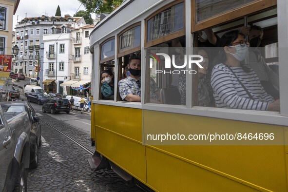 People wearing protective masks are seen riding through the streets of the Graça neighborhood by tram. Lisbon, June 24, 2022. In Portugal, c...