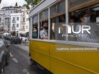 People wearing protective masks are seen riding through the streets of the Graça neighborhood by tram. Lisbon, June 24, 2022. In Portugal, c...