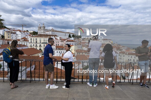 Tourists are seen observing the historic center of the city from Das Portas do Sol viewpoint. Lisbon, June 24, 2022.  